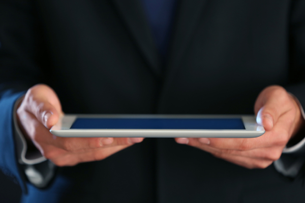Business professional holding tablet to illustrate digital incident response policy and cybersecurity planning.