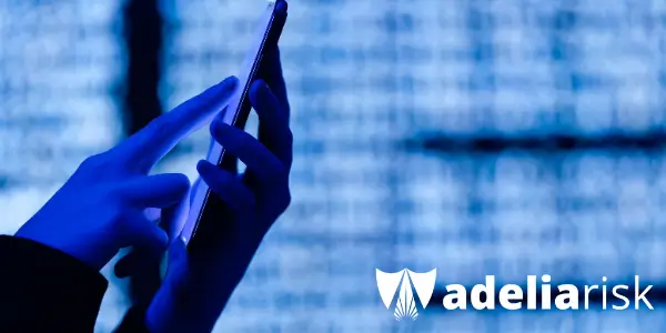 Silhouette of a person using a smartphone with code in the background and the Adelia Risk logo, symbolizing real-world fractional CISO insights and cybersecurity preparedness