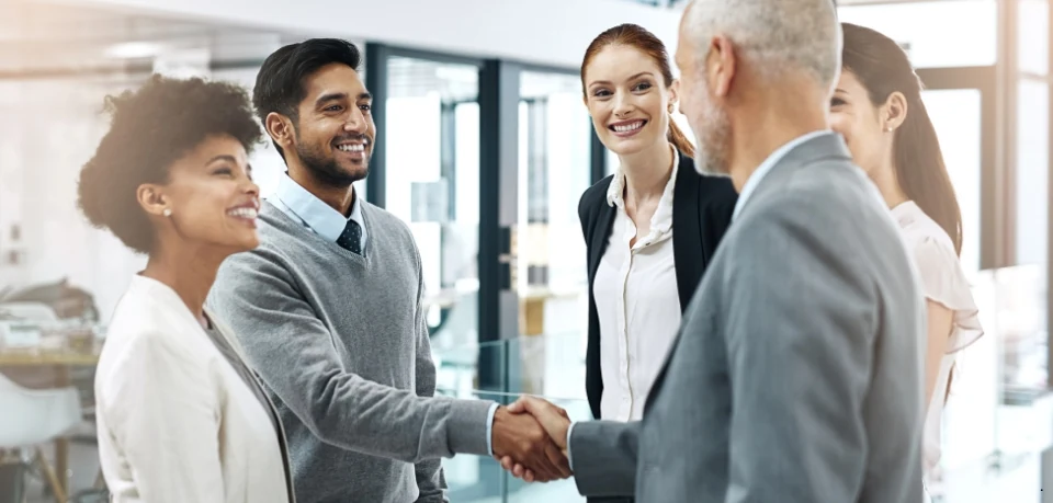 Adelia Risk team shaking hands with a client in a long-term cybersecurity partnership